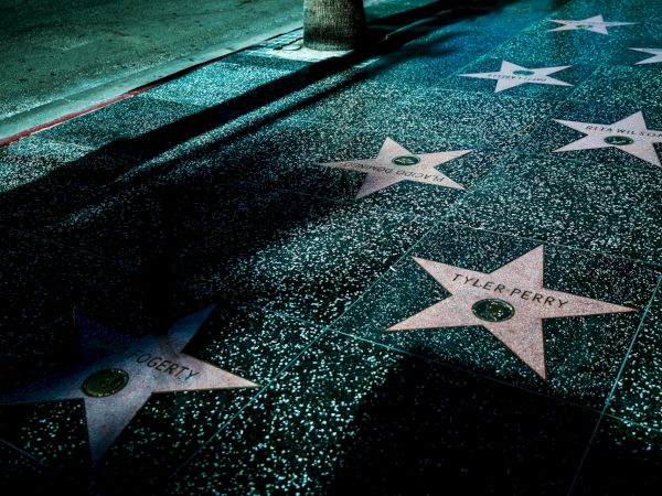 Stars on the Hollywood Walk of Fame are visible on the sidewalk, featuring names of celebrities like Tyler Perry.