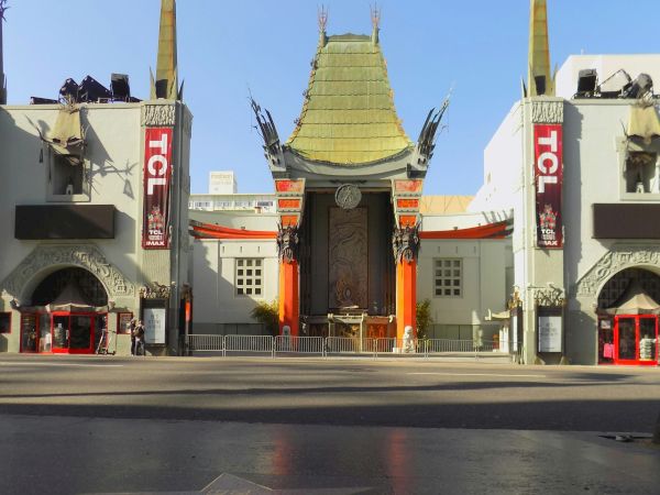 The image shows a landmark theater with ornate architecture and a star on the sidewalk in front.